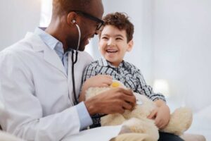 Doctor holding smiling young child
